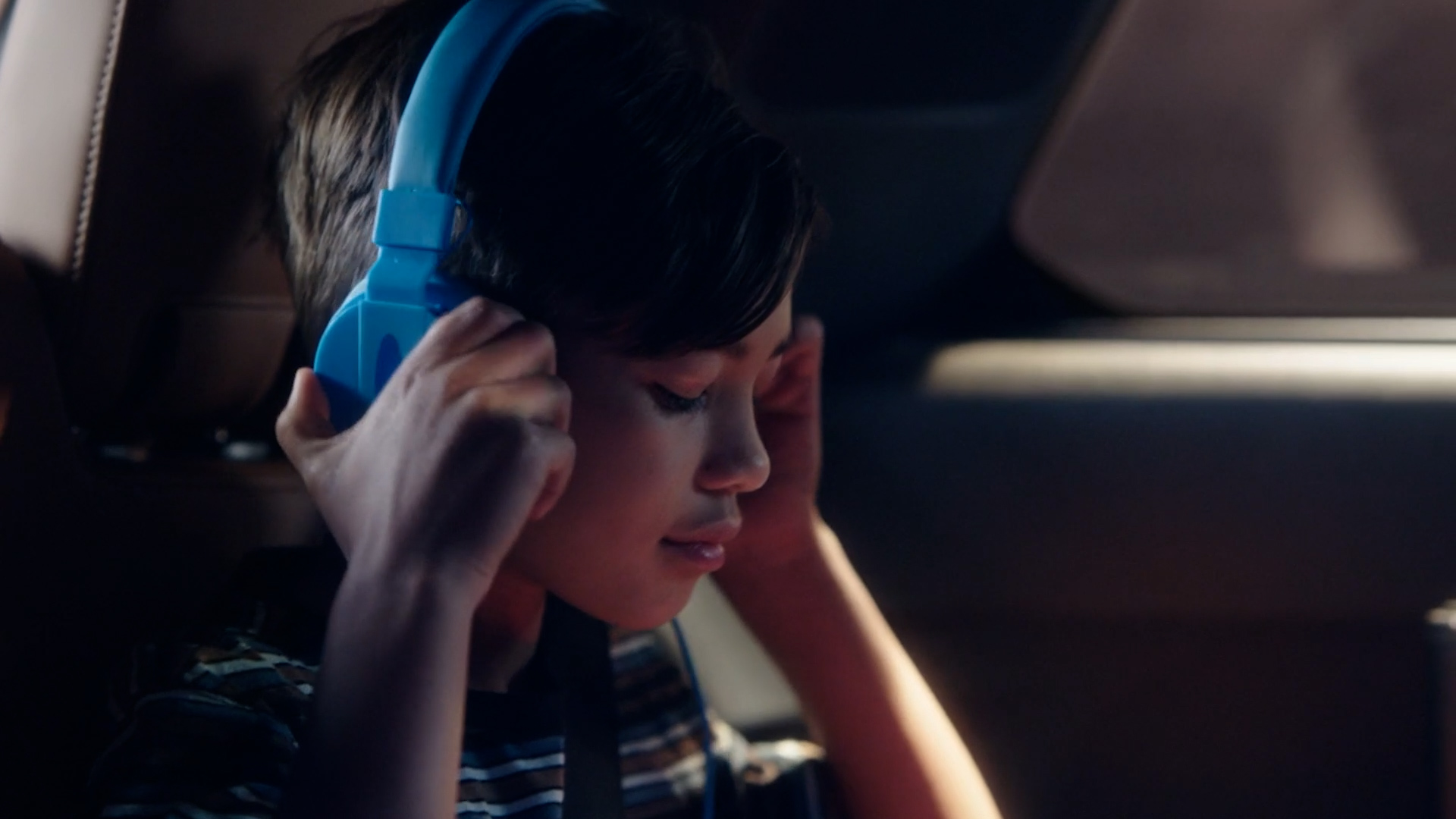 Girl listening with headphones in the 2022 INFINITI QX60 Crossover